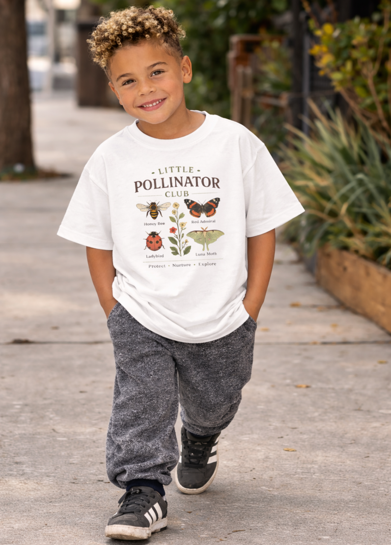 Child wearing a 'Little Pollinator Club' t-shirt outdoors