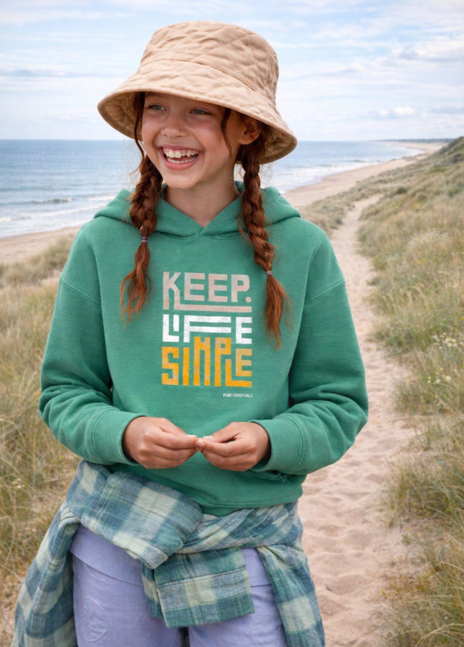 Person wearing a green hoodie with 'Keep Life Simple' text on a beach